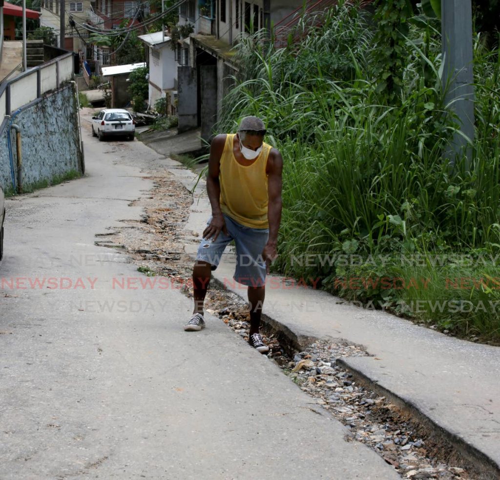 A man stands on Angelina Terrace, Morvant on Thursday. The road has remained in a state of extreme disrepair after WASA works were completed a year ago. Photo by Sureash Cholai 