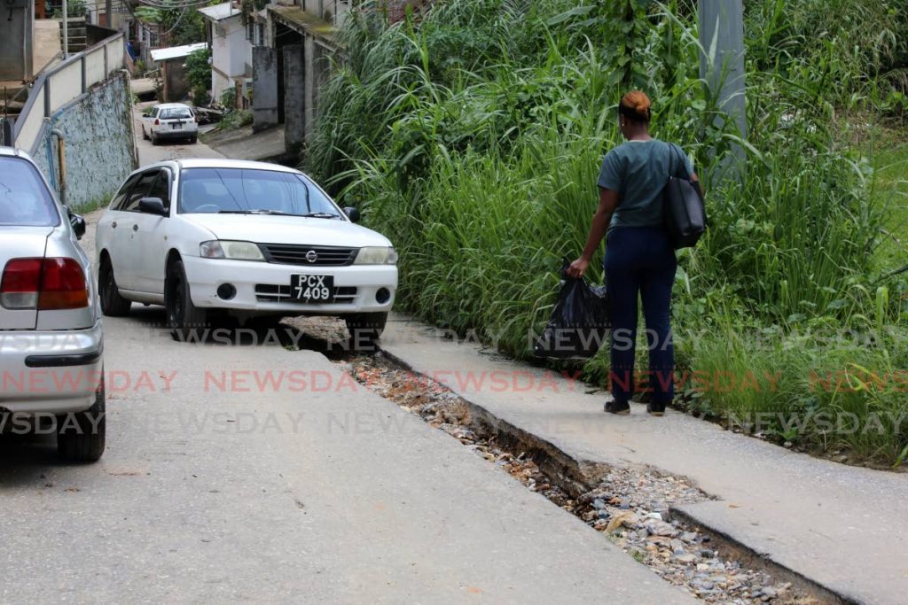 A car tries to make its way along Angelina Terrace, Morvant on Thursday. The road has remained in a state of extreme disrepair after WASA works were completed a year ago. Photo by Sureash Cholai