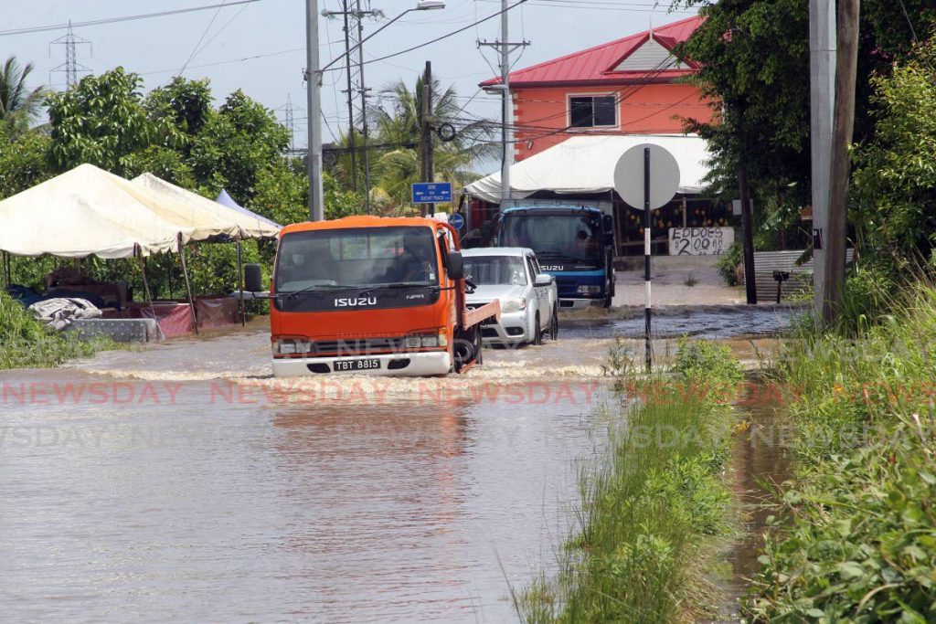 In this file photo, motorists driving through flood waters along Debe trace, Debe following heavy rainfall. - Photo by Lincoln Holder