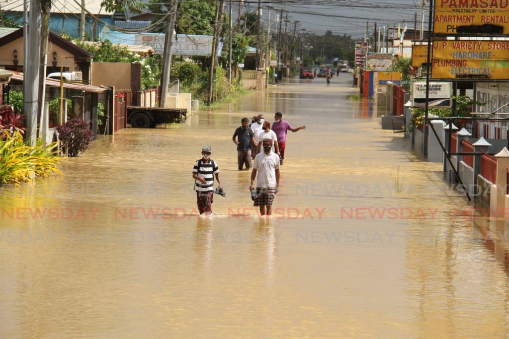 In this August 20 file photo, St Helena residents leave the area after the Caroni river overflowed causing massive flooding. - Photo by  Ayanna Kinsale