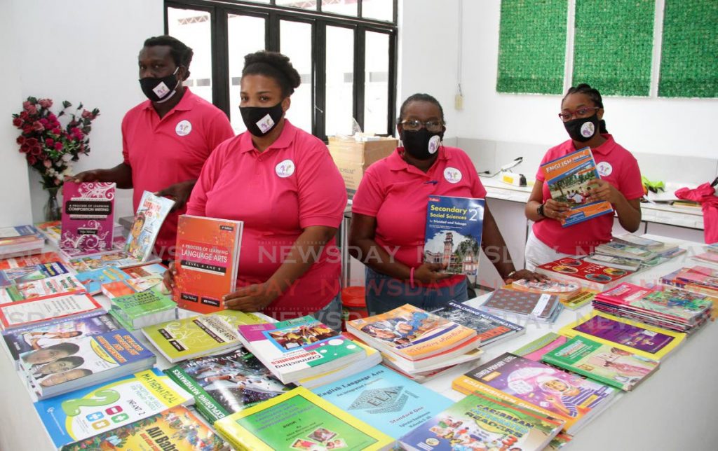 Aspiring Minds Foundation NGO members (from left) Deon Dyer, director Betty Ann Byng, Curleen Springer and Makeba Springer, show some of the schoolbooks being distributed at their Back to Home School Supplies Assistance at Gransul Road, San Fernando on Monday. Photo by Angelo Marcelle.