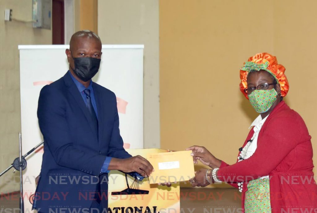 Elroy Julien, CEO of the National Commission for Self Help, presents Sharon Tinto with her grant. - Photo by Sureash Cholai