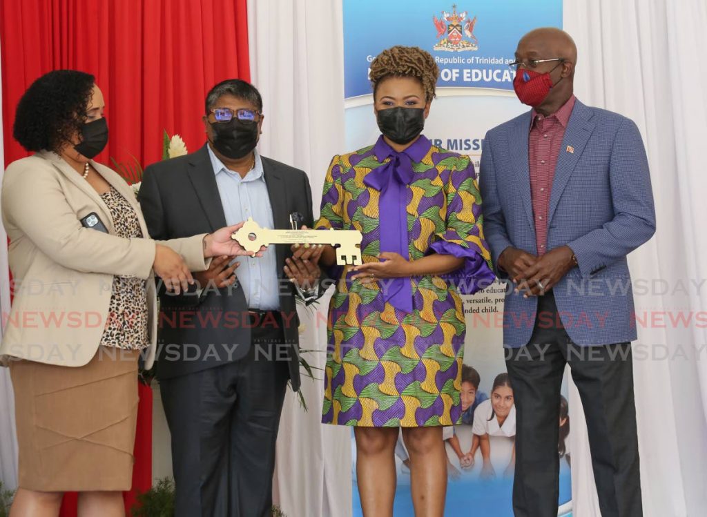 Prime Minister Dr Keith Rowley, right, lookS on as MTS CEO Lennox Rattansingh, second from left, hands over the keys to the Malabar Government Primary School to Education Minister Dr Nyan Gadsby-Dolly, second from right, and Minister in the Ministry of Education Lisa Morris-Julian  at the commissioning ceremony of the school, Thursday. - Photo by Sureash Cholai