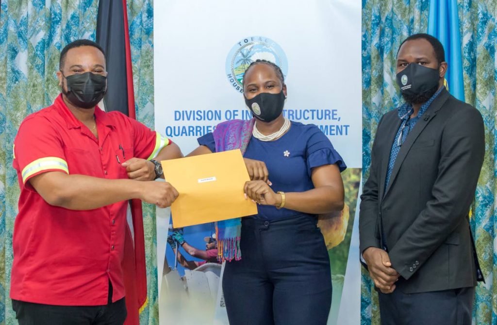 Secretary of Infrastructure, Quarries and the Environment Kwesi Des Vignes, left, presents instrument of appointment to new environmental officer Crystal Edwards, as Garth Ottley, Director (Ag) Department of Marine Resources and Fisheries, looks on. - DIQE
