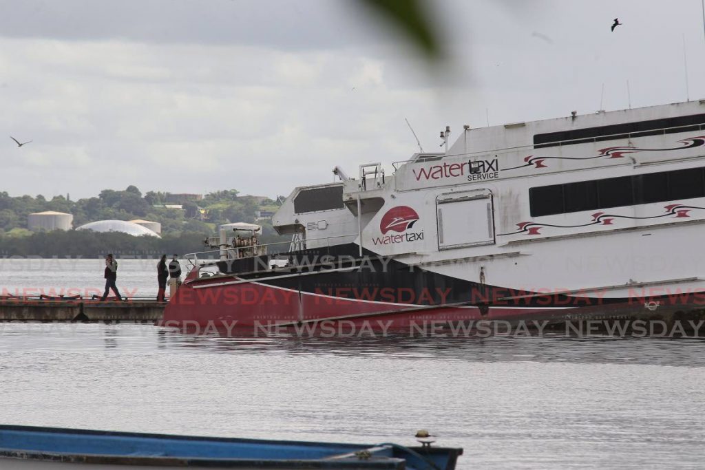 Officials at the scene of a tilting Carnival Runner, a 41-metre high speed passenger catamaran ferry, taking on water at the water taxi terminal, King's Wharf, Lady Hailes Avenue in San Fernando. - Photo by Lincoln Holder