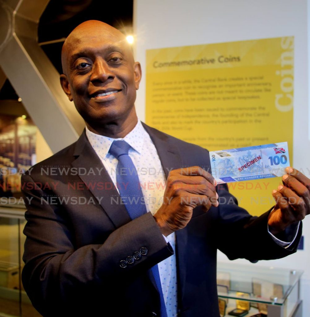 In this 2019 photo, Central Bank governor Dr Alvin Hilaire shows a specimen of the new $100 note. FILE PHOTO/SUREASH CHOLAI
 - 