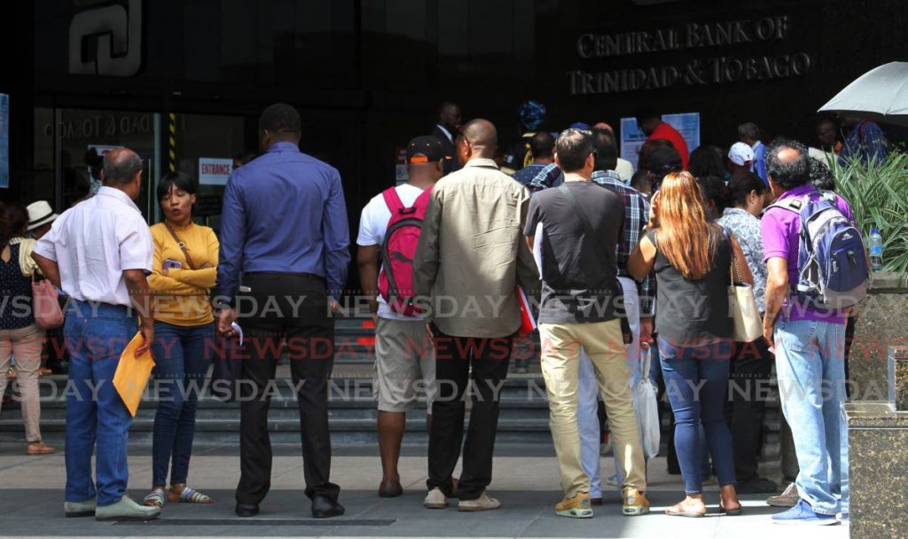 In this March 17, 2020 photo people line up to enter the Central Bank in Port of Spain. File photo/Angelo Marcelle - 