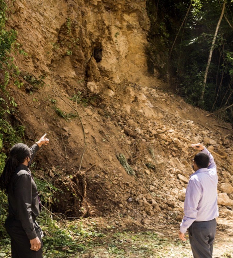 Rohan Sinanan, Minister of Works and Transport (right) and Jimelle Wilson (left), St George West district engineer of the Highways Division examine the aftermath of the landslide at the North Coast Road. Photo courtesy Works Ministry.