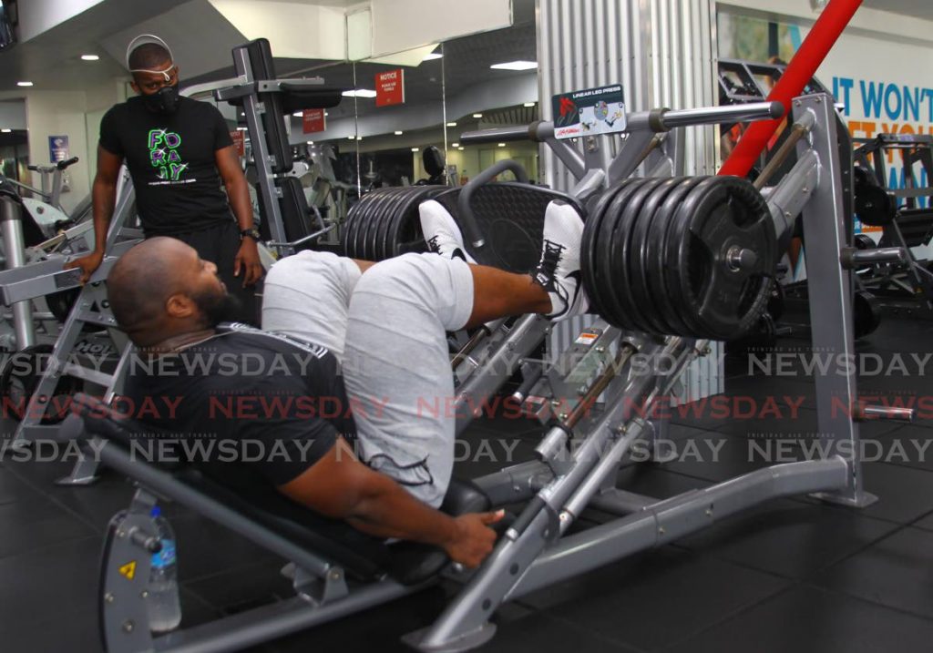 In this October 26, 2020 file photo, Aaron ‘Tiny’ Richards demonstrates a leg press, at the D’Dial Fitness Club, Long Circular Mall.  - Photo by Roger Jacob