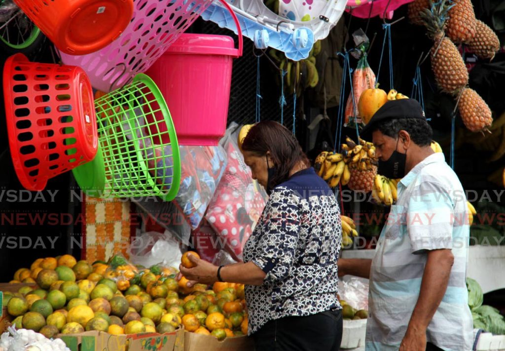 A vendor stacks fruits on her stand in San Juan on February 26. Confederation of Regional Business Chambers coordinator Jai Leladharsingh says the government must facilitate economic growth. - PHOTO BY AYANNA KINSALE