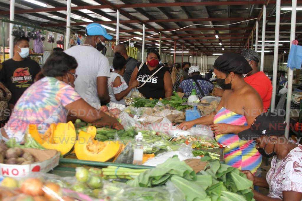 Customers consider what vegetables and produce to buy at a stall in the Tunapuna market. File photo. Transforming food systems is essential to achieve food security, improve nutrition and put healthy diets within reach of all. - 