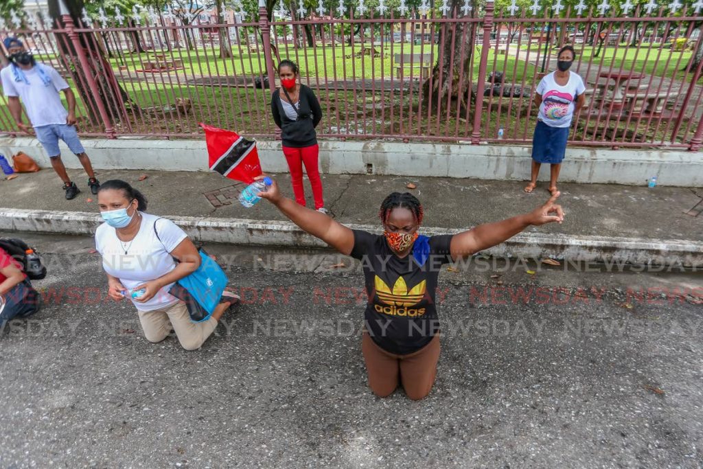 People kneel in front the Red House, opposite Woodford Square, to pray that there is no mandatory vaccination of children. Photo by Jeff Mayers - Jeff Mayers