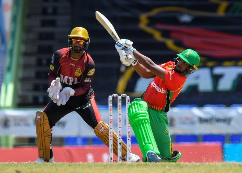 Nicholas Pooran (R) of Guyana Amazon Warriors hits 6 as Denesh Ramdin (L) of Trinbago Knight Riders watch during the 2021 Hero Caribbean Premier League match 11 at Warner Park Sporting Complex on Wednesday. Photo courtesy CPL T20
