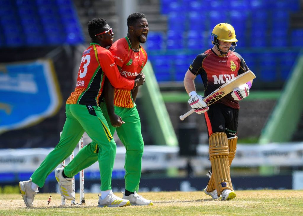 Romario Shepherd (2L) and Kevin Sinclair (L) of Guyana Amazon Warriors celebrate winning against the Trinbago Knight Riders in the super over during the 2021 Hero Caribbean Premier League match 11 at Warner Park Sporting Complex on Wednesday. At right, TKR's Tim Seifert walks towards the pavillion. - Photo courtesy CPL T20