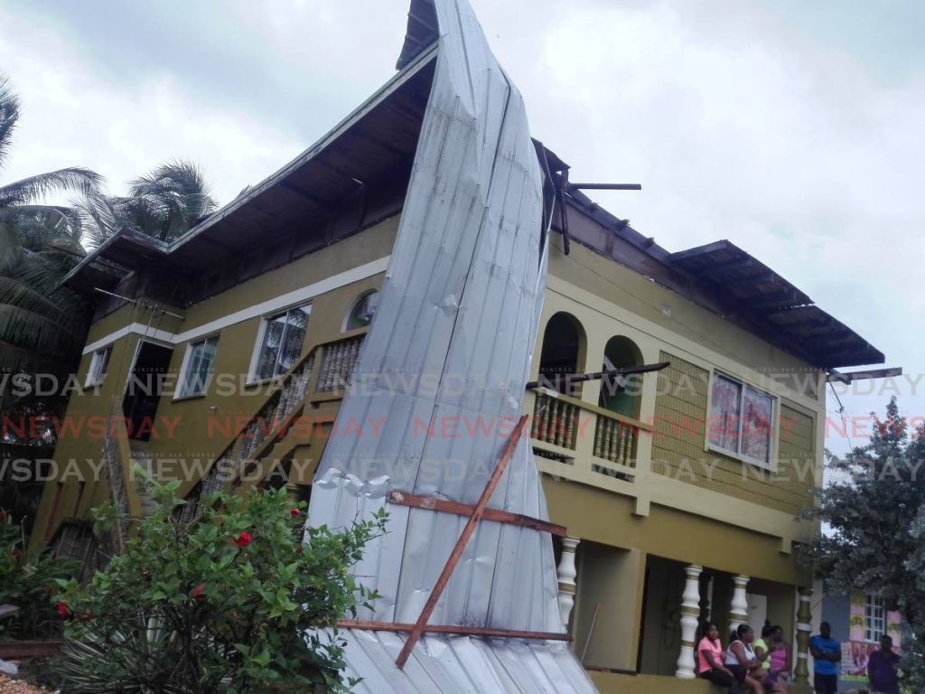 The mangled galvanize draped on this two-storey house in North Oropouche in Sangre Grande, displaying the tremendous intensity of the adverse weather during the early morning hours on Friday. - Photo by Stephon Nicholas