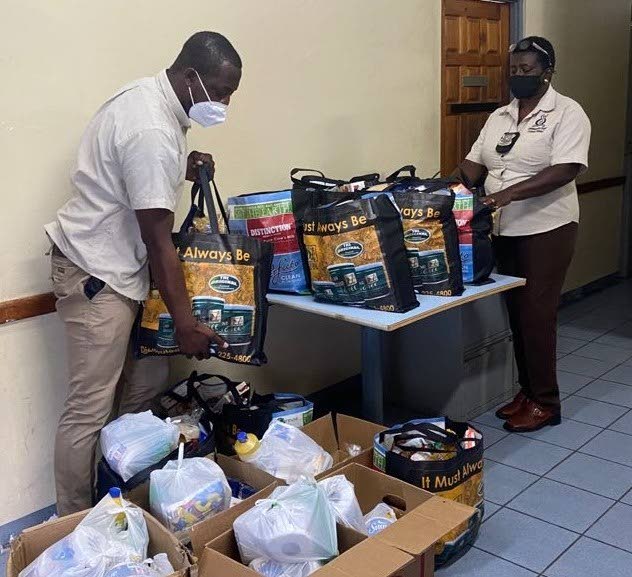 Two representatives of the TTPS Community Policing Unit, Tobago Division, package hampers courtesy a partnership with bmobile for distribution to needy Tobagonians.  