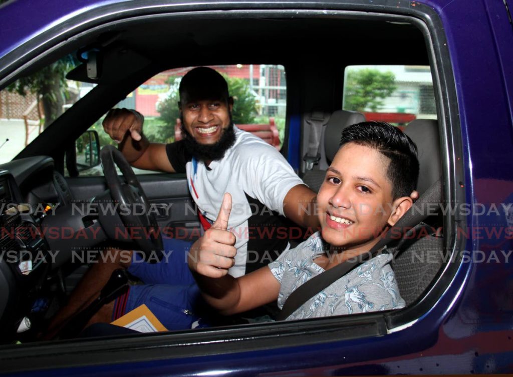 Kaleem Shamsoodeen of the Gandhi Memorial Vedic School shows the camera a big smile, alongside his father, after collecting his 2021 SEA results. The school implemented a 