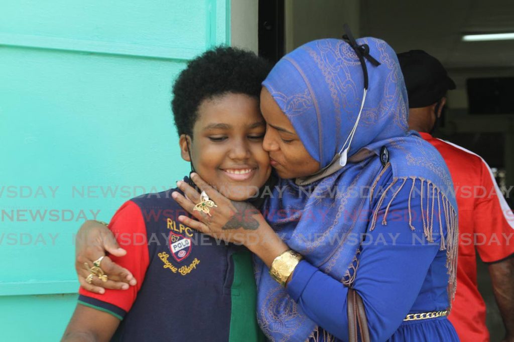 Mommy's boy, Richards Rondell, a student of Lendore Village S.D.M.S Primary School Enterprise, is kissed by his mother after getting his SEA results on Thursday. Photo by Marvin Hamilton