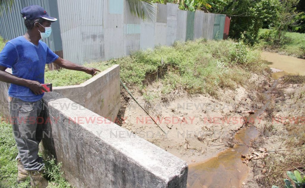 Resident Ramdeo Ramsawak of Kanhai Road North, Barrackpore points to a drain filled with chemicals from a nearby business place seeping into the South Oropouche river. The smell emanating is causing problems for residents. - Lincoln Holder