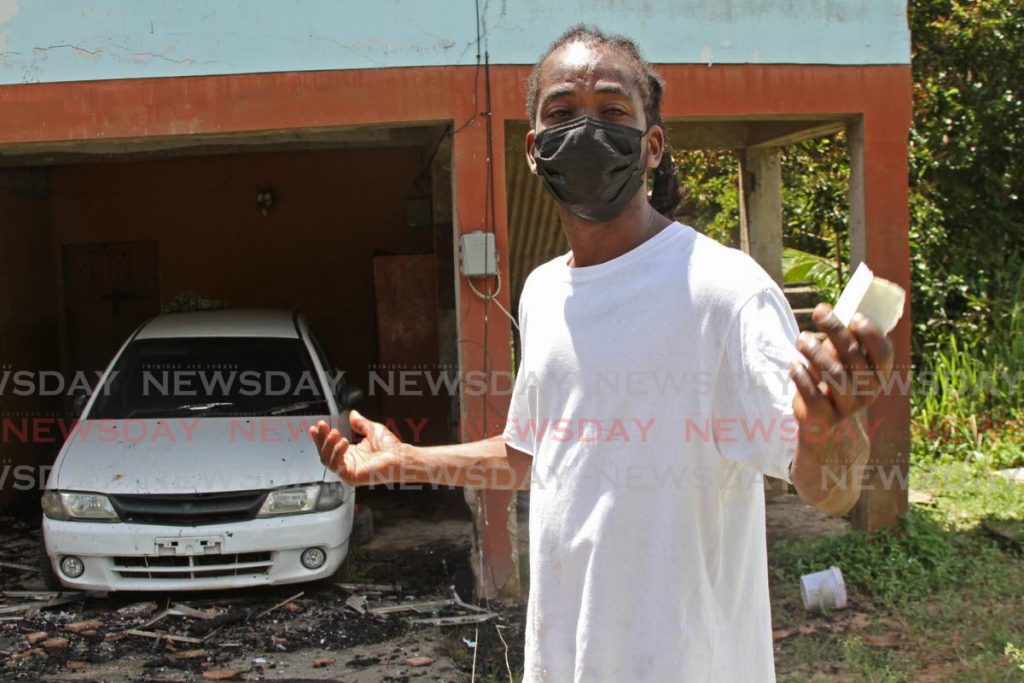 A tearful Shawn Charles at his home on Cedar Road, Claxton Bay, on Saturday morning, after it was gutted by a fire on Friday night. - Photo by Marvin Hamilton