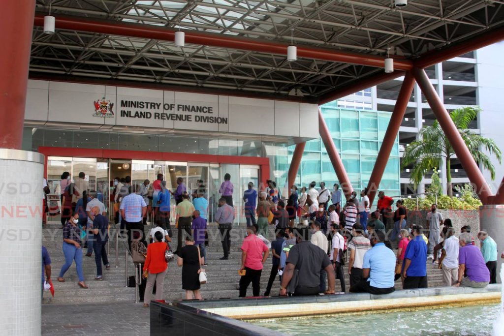 File photo: People wait outside the Ministry of Finance Inland Revenue office at the Government Plaza, Richmond Street in Port of Spain on Tuesday. Photo by Angelo Marcelle