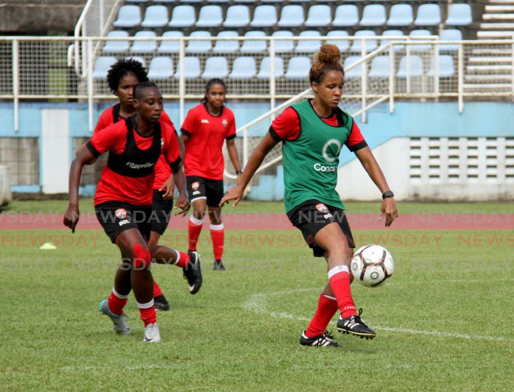 Former national captain Maylee Attin-Johnson, right, kicks the ball during a national training session on Wednesday at the Ato Boldon Stadium, Couva. PHOTO BY AYANNA KINSALE - 