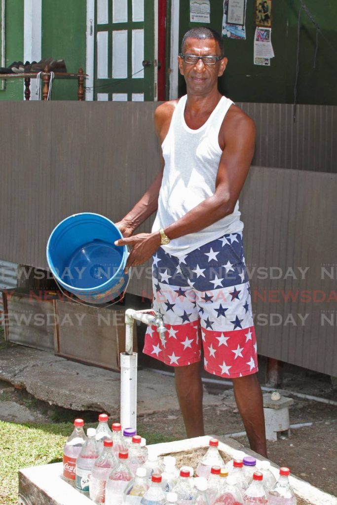 Charran Francis of Ecclesville Road, Rio Claro, hardly got time to stock up on water. - Photo by Marvin Hamilton