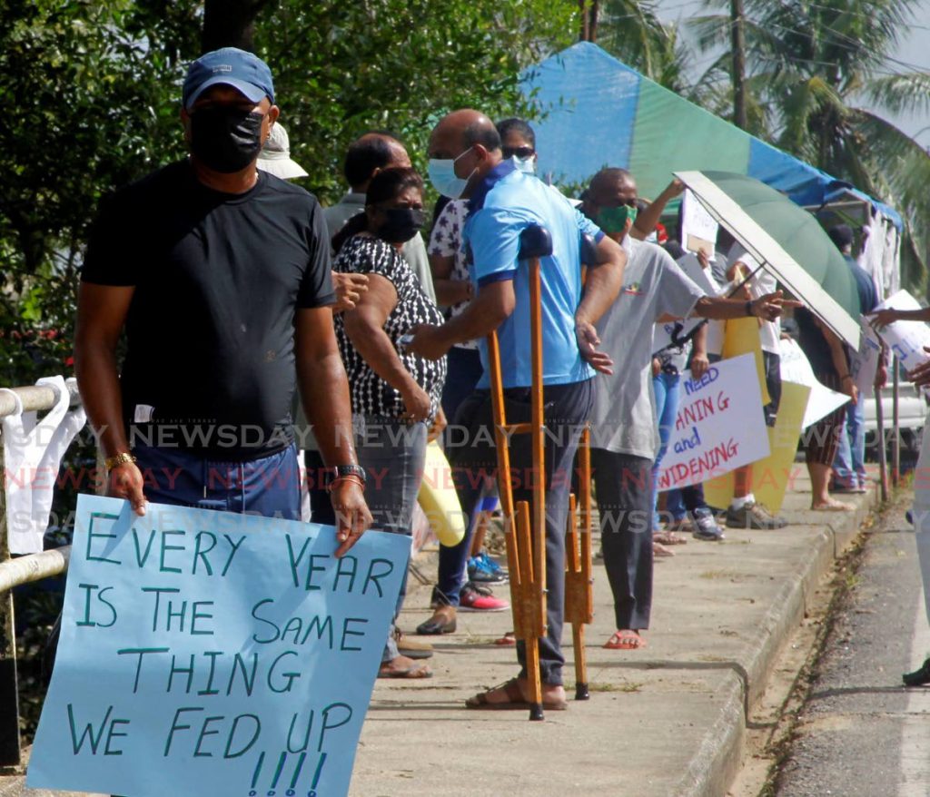 Woodland residents line La Fortune Pluck Road on Saturday during a demonstration for measures to curb flooding in south Trinidad. - PHOTO BY ROGER JACOB