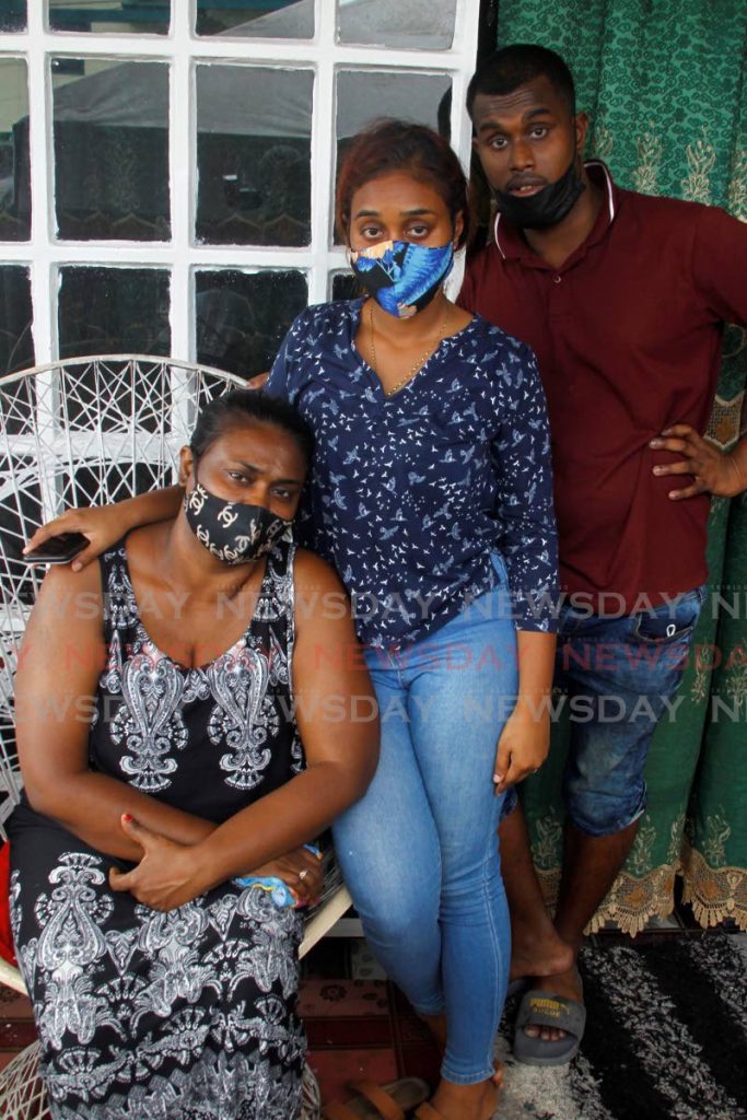 Sumita Cazabo and her children Emily and Amrit at their home in Golconda on Saturday morning. The family mourned the murder of  vendor Anildath Cazabo at his stall on Friday. - PHOTO BY ROGER JACOB