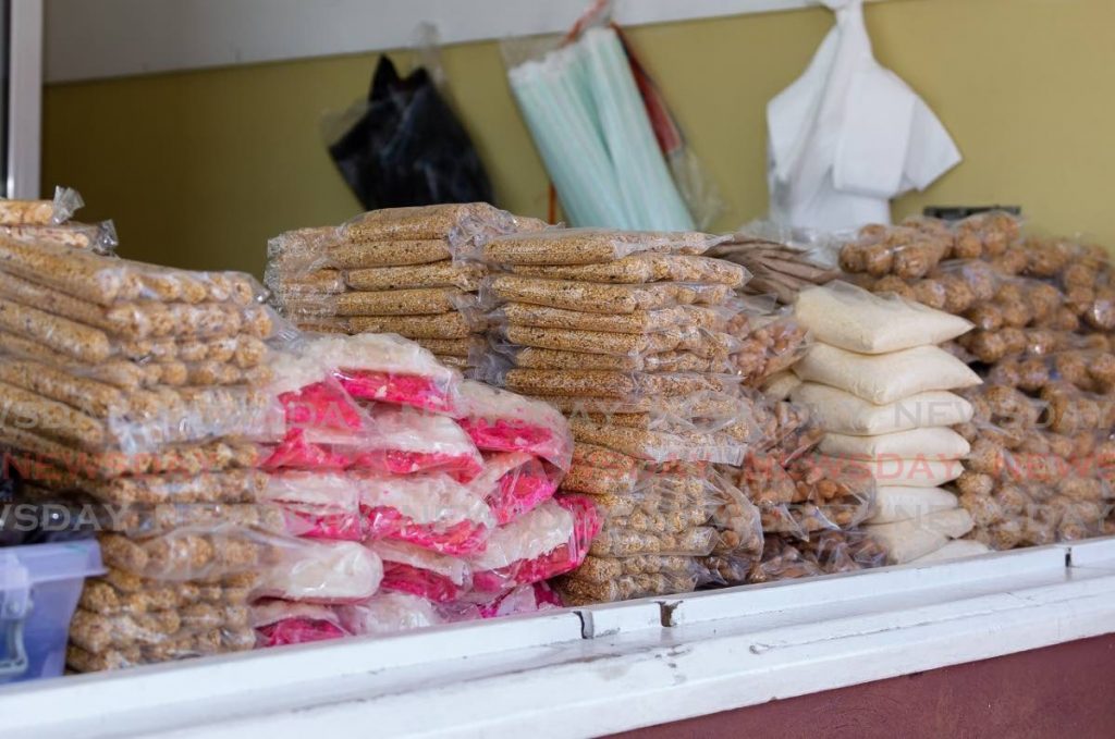 Bene sticks and balls among sugar cakes and other local sweets at a vendor's stall in Tobago. - Photo by David Reid