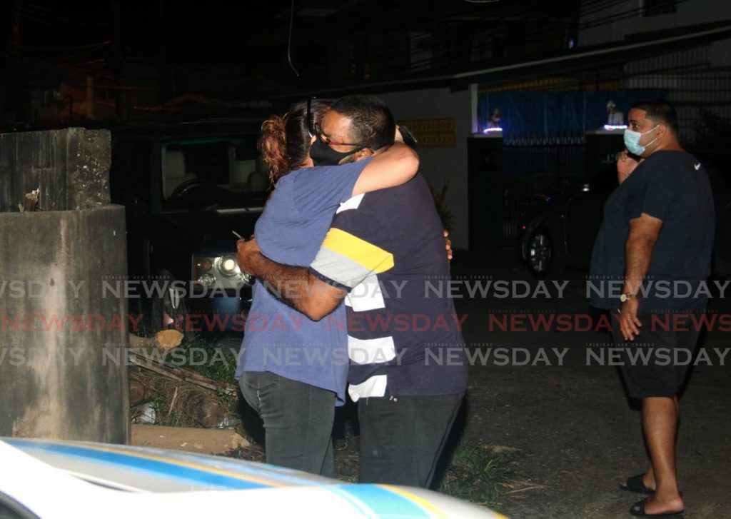 Relatives of murder victims Kumarie Kowlessar-Timal, Radeshka Timal-David and Zachary David console each other at the family's home on Oudan Trace, El Socorro where they were killed last Friday. Photo by Ayanna Kinsale