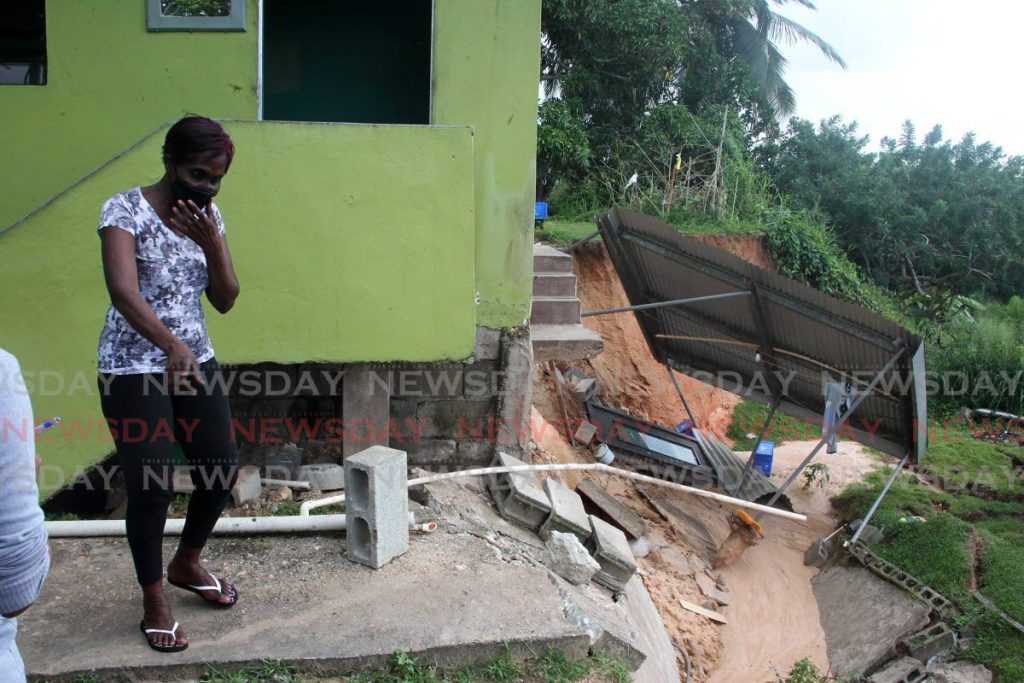 Marva Fritz shows Newsday the new areas of erosion at the back of her house after the weekend rainfall at Diamond Road Claxton Bay on Monday. - ROGER JACOB