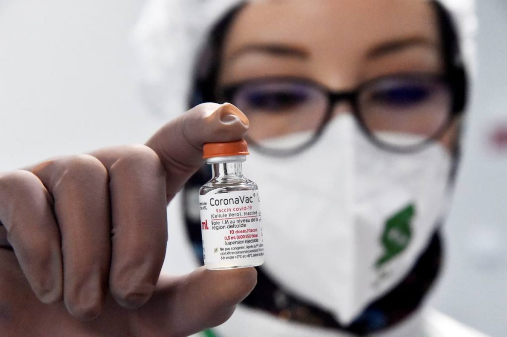 A person shows a dose of the CoronaVac covid19 vaccine at the Saidal factory in Constantine, Algeria on Wednesday. The country's first home-produced coronavirus vaccines came off the assembly line, as part of a cooperation deal with the makers of China's Sinovac vaccine. Authorities say the makers aim to produce up to five million doses per month. (AP Photo) - 