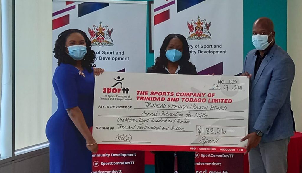 Trinidad and Tobago Hockey Board assistant treasurer Cindy Martin Faustin, centre, accepts a cheque from Minister of Sport Shamfa Cudjoe, left, and Justin Latapy George, head of the Sport Development Unit, Sport Company, at a grant distribution ceremony on Monday at Nicholas Tower, Port of Spain. - 