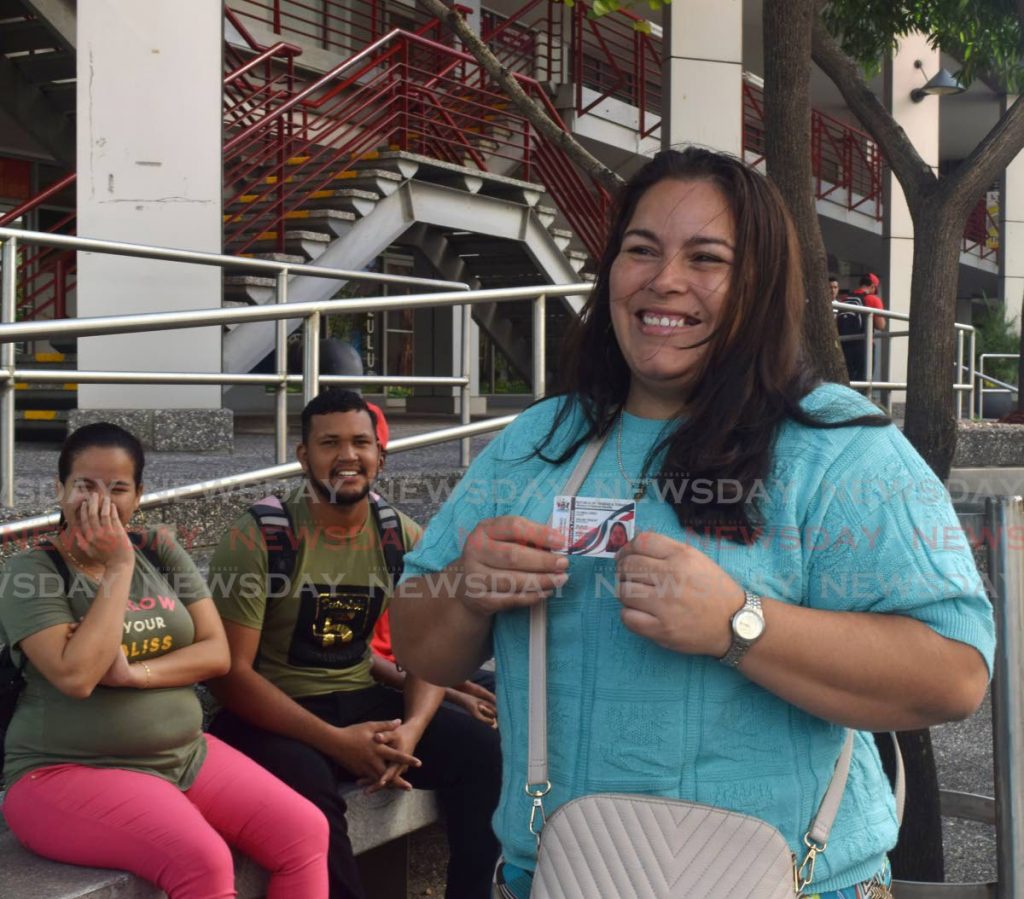 Venezuelan Flores Lopez shows off her registration card at Richmond Street, Port of Spain.  - File photo