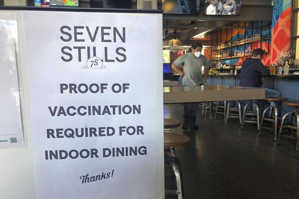 In this July 29 file photo, a proof of vaccination sign is posted at a bar in San Francisco. As more businesses reopen following the latest covid19 shutdown, companies must clearly communicate their new policies. - AP PHOTO