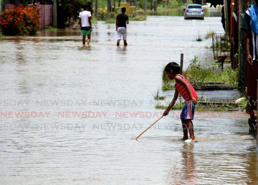 In this August 2020 file photo, a child measures the depth of flood water along Madras Road, St Helena. Photo by Ayanna Kinsale