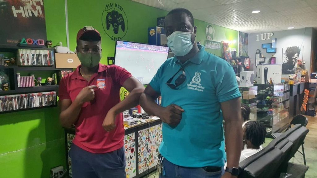 Michael Ramsey, left, with acting Cpl Larry Braithwaite, leader of the Mt St George Police Youth Club, after winning the Tobago division of the police FIFA online football tournament.  - 