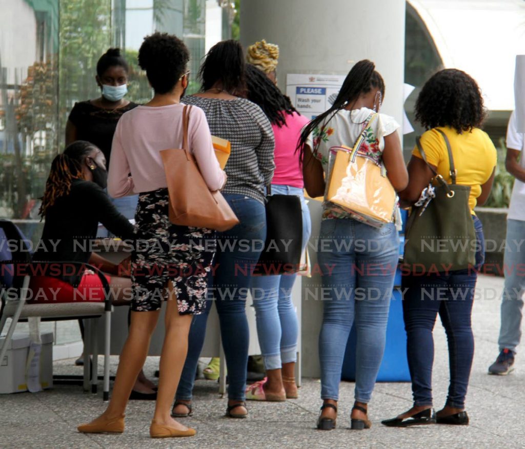 Teaching hopefuls wait in line to submit their application forms at the Ministry of Education in Port of Spain on Thursday. - AYANNA KINSALE