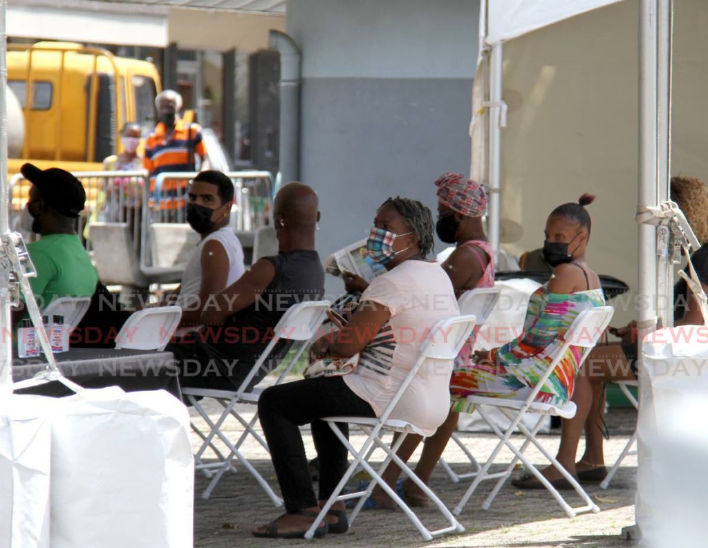 Citizens sit in the observation area after receiving the Johnson and Johnson vaccine at the vaccination drive at the Brian Lara Promenade.  - Photo by Ayanna Kinsale