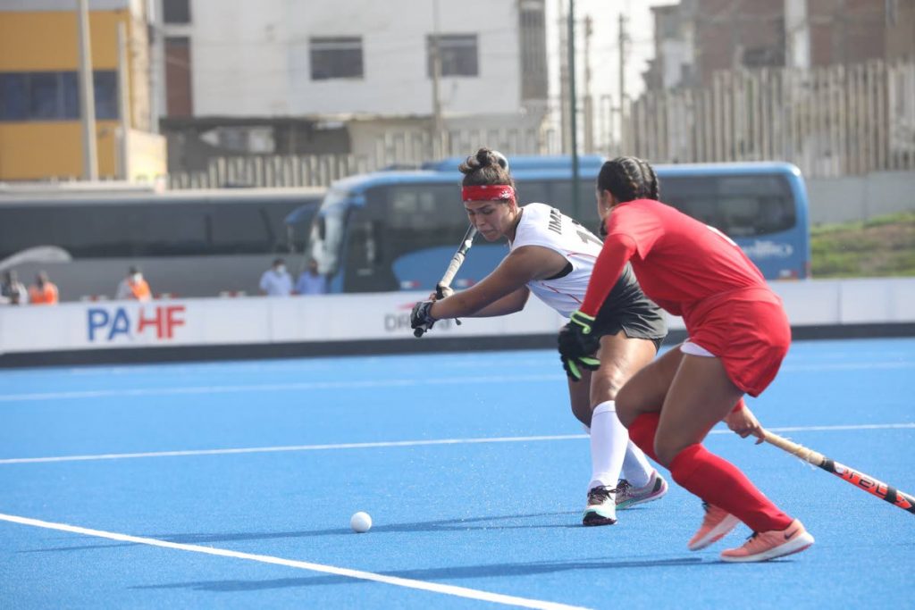 Peru's Maria Jimenez (left) attempts a shot while under pressure from Trinidad and Tobago's Brianna Govia during the teams' final of the Pan Am Challenge, in Lima, Peru on Saturday. PHOTO COURTESY PAN AM HOCKEY. - 