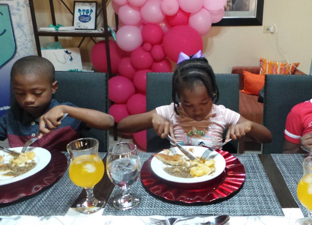Children eating with knife and fork. Agriculture Minister Clarence Rambharat encourages parents to teach children how to eat properly, especially when dining. - 