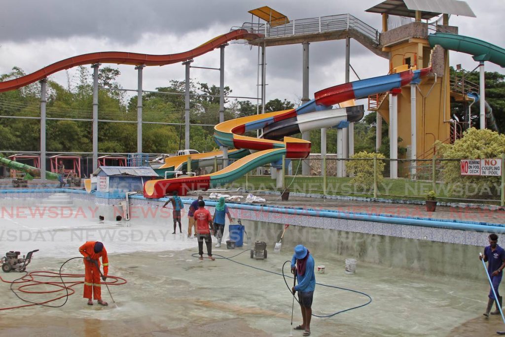 Workers clean and repaint a pool and slide at Harry's Water Park, Tabaquite to be ready to reopen later this month. Photo by Marvin Hamilton