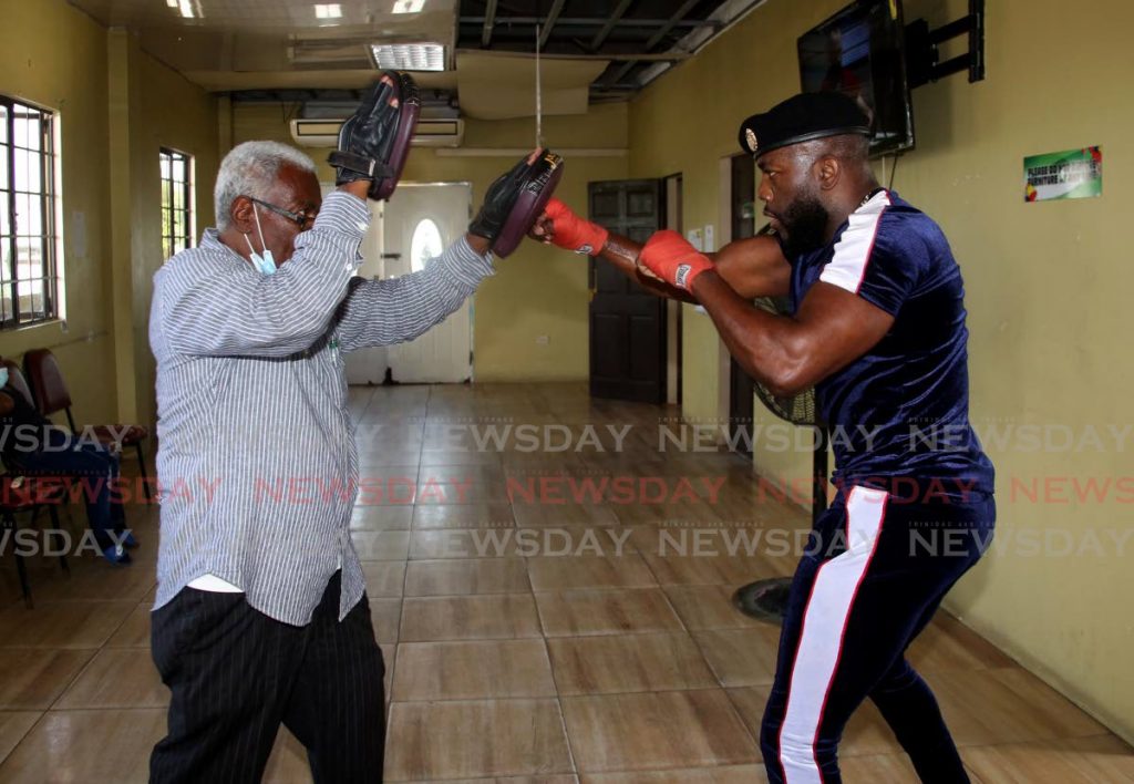 Soca artiste Marvin “Swappi” Davis (right) sparing with boxing promoter Buxo Potts at the Sea Lots Community Centre in Port of Spain.  - Photo by Sureash Cholai