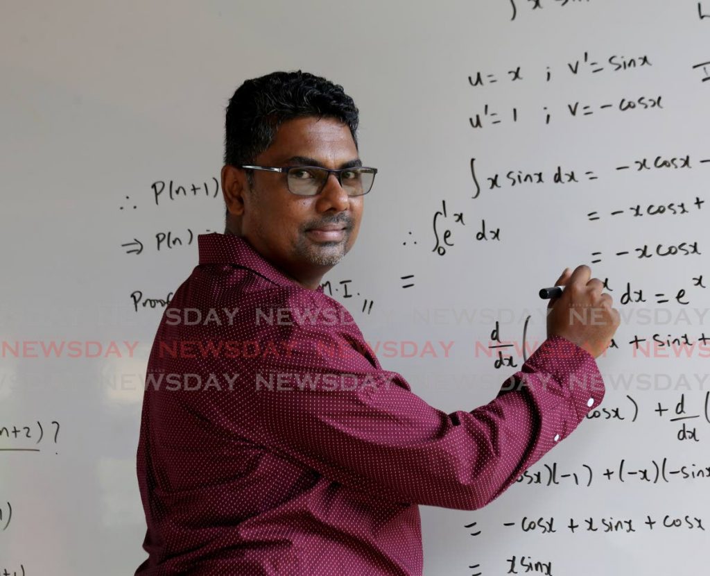 Mathematician Dr Dayle Jogie solves one of his equations. - PHOTO BY SUREASH CHOLAI
