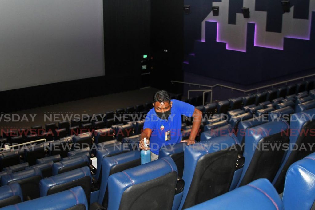 Operations supervisor at Movie Towne, C3 Centre, Kevin Ramsubhag, sanitises seats. - Marvin Hamilton