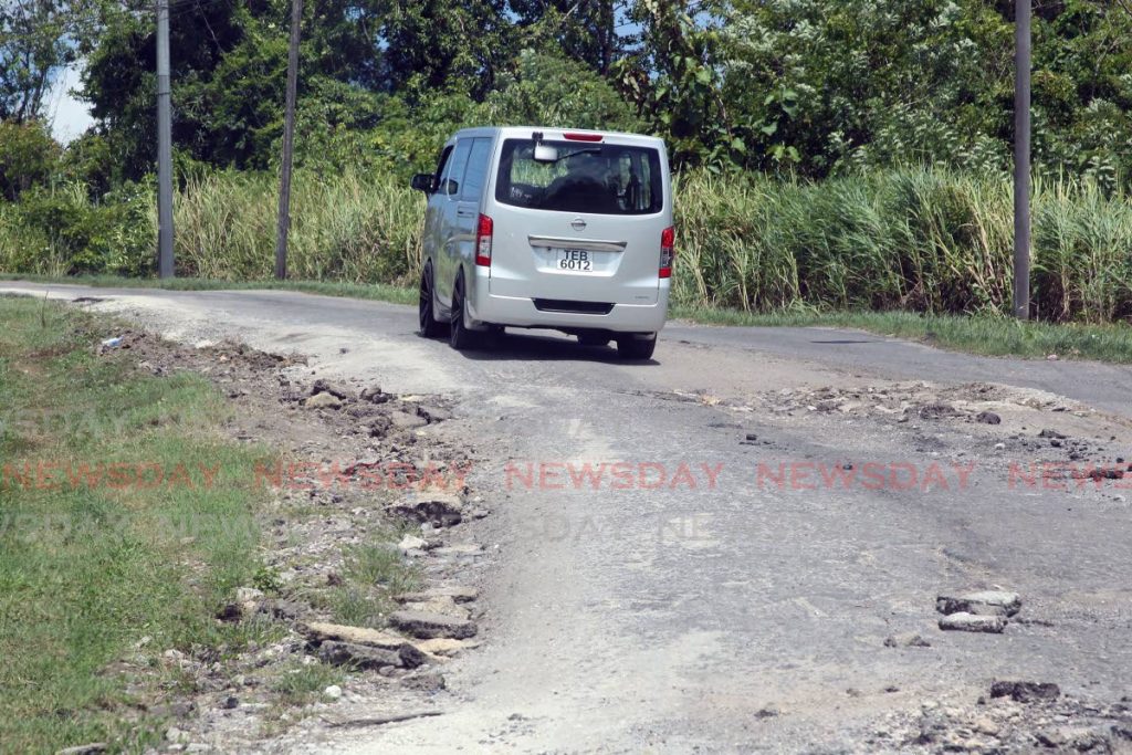 A driver proceeds slowly along a bumpy road in Barrackpore. Works and Transport Minister Rohan Sinanan on Friday said he wished he could spend billions to fix the country's roads. - Photo by Lincoln Holder
