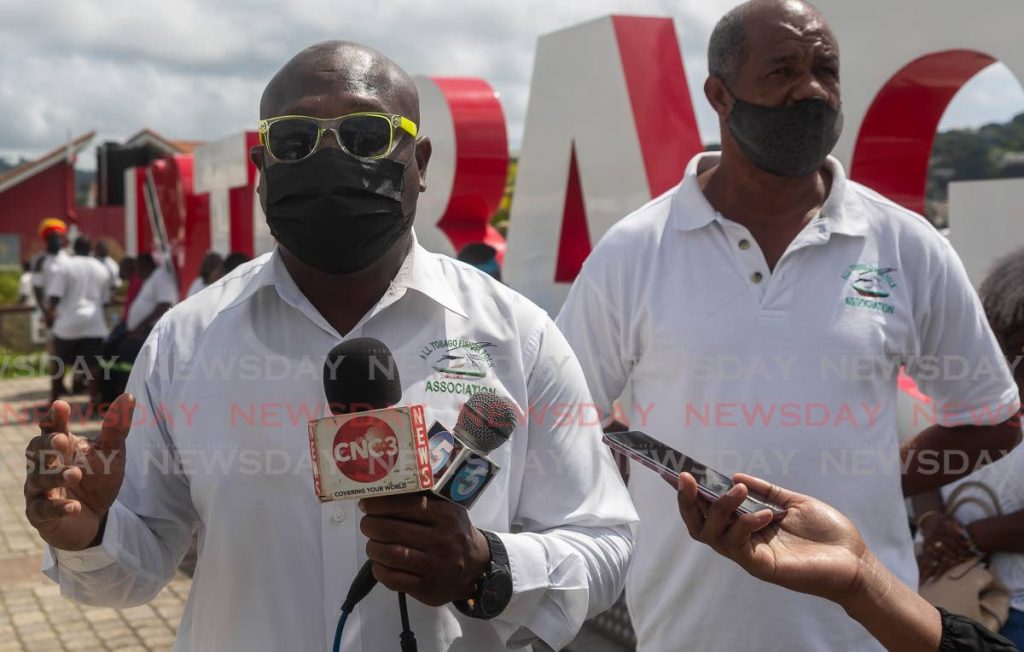 Curtis Douglas, left, vice president of the All Tobago Fisherfolk Association, speaks to the media at a news conference in Scarborough on Tuesday. - 