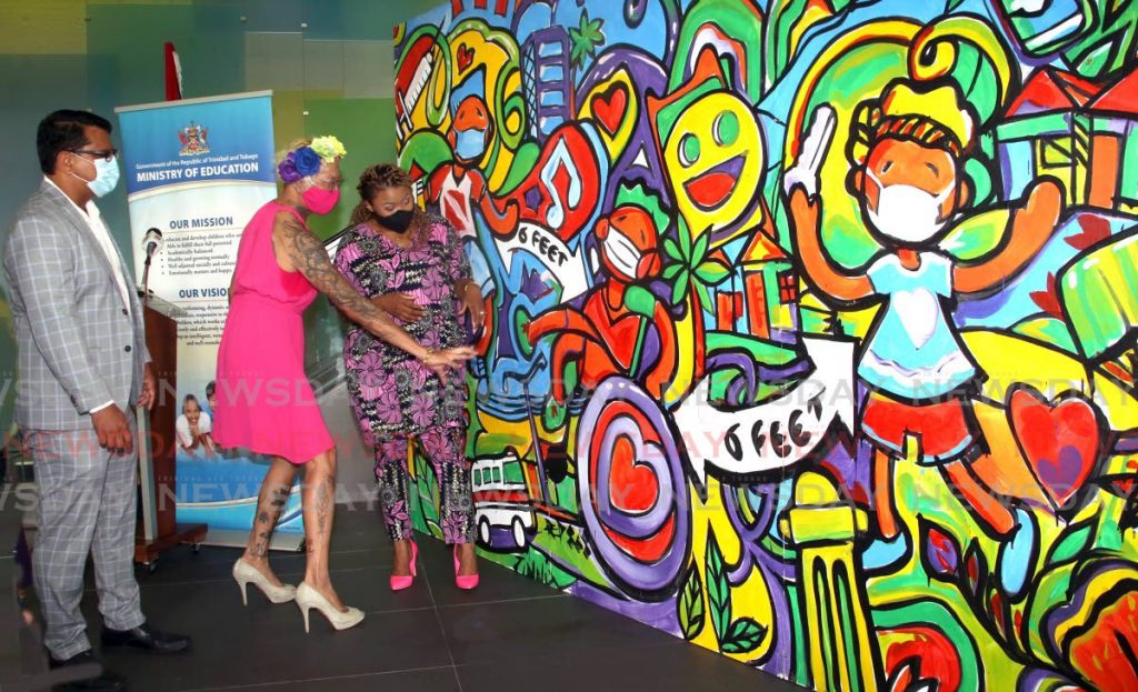 Education Minister Dr Nyan Gadsby-Dolly (right) listens to artist Zinnia Li (middle) as she explains details of the mural which she did and was donated to her ministry by the American Chamber of Commerce. With them is the chamber's CEO Nirad Tewari.

about her mural on the lobby of her ministry head office on St Vincent Street , Port of Spain, that was handed over by the American Chamber of Commerce(AMCHAM), with them on the left is AMCHAM CEO Nirad Tewari  - SUREASH CHOLAI