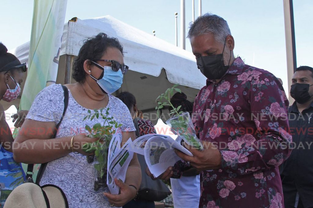 Minister of Agriculture Clarence Rambharat recieves plants and seedlings from a member of Wold Food Day National Committee at the ministry's car park Chaguanas on Saturday.  - Photo by Marvin Hamilton